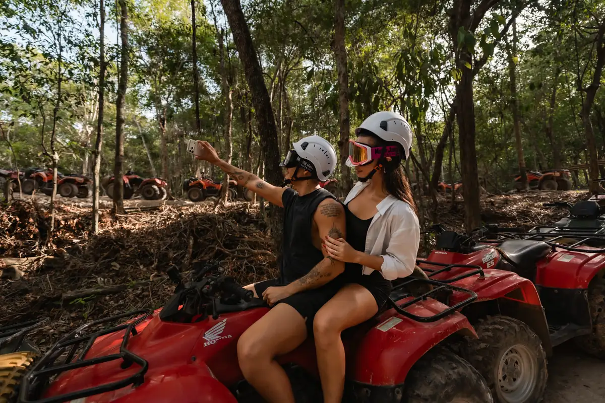 Pareja en una cuatrimoto señalando la selva durante un tour