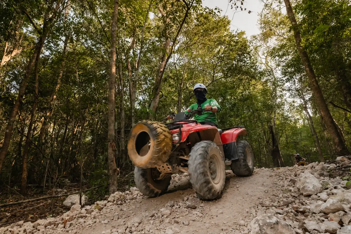 ATV driving through a muddy jungle track