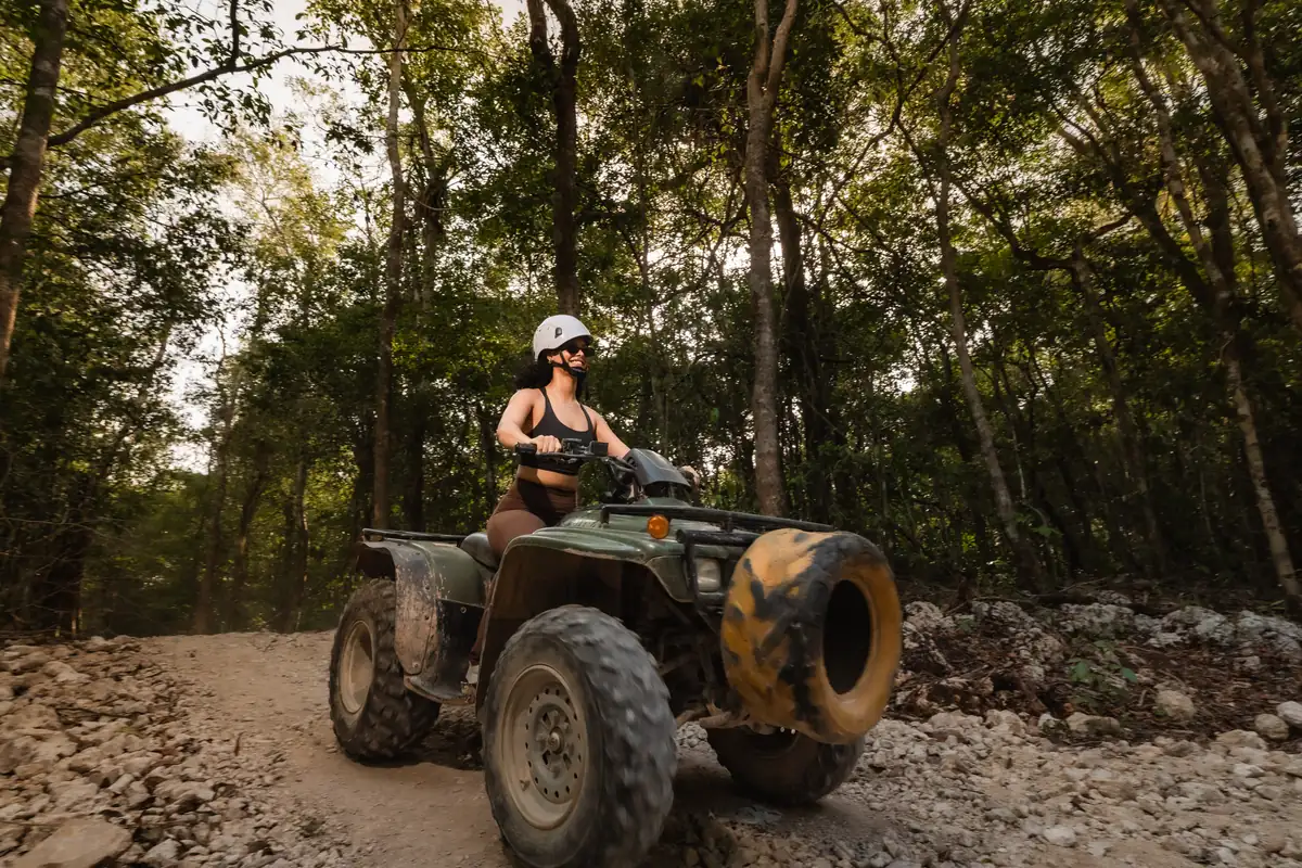 Persona en cuatrimoto en un sendero soleado de la selva cerca de Cancún