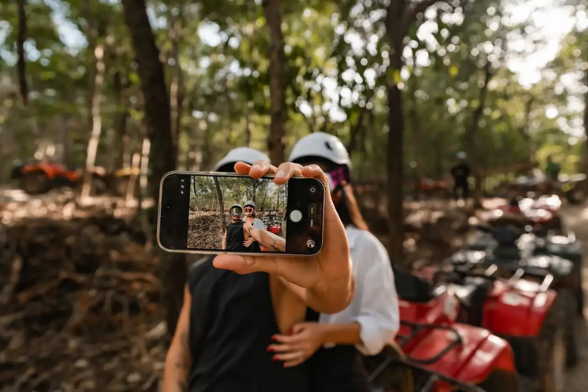 Friends taking a selfie on ATVs in the jungle