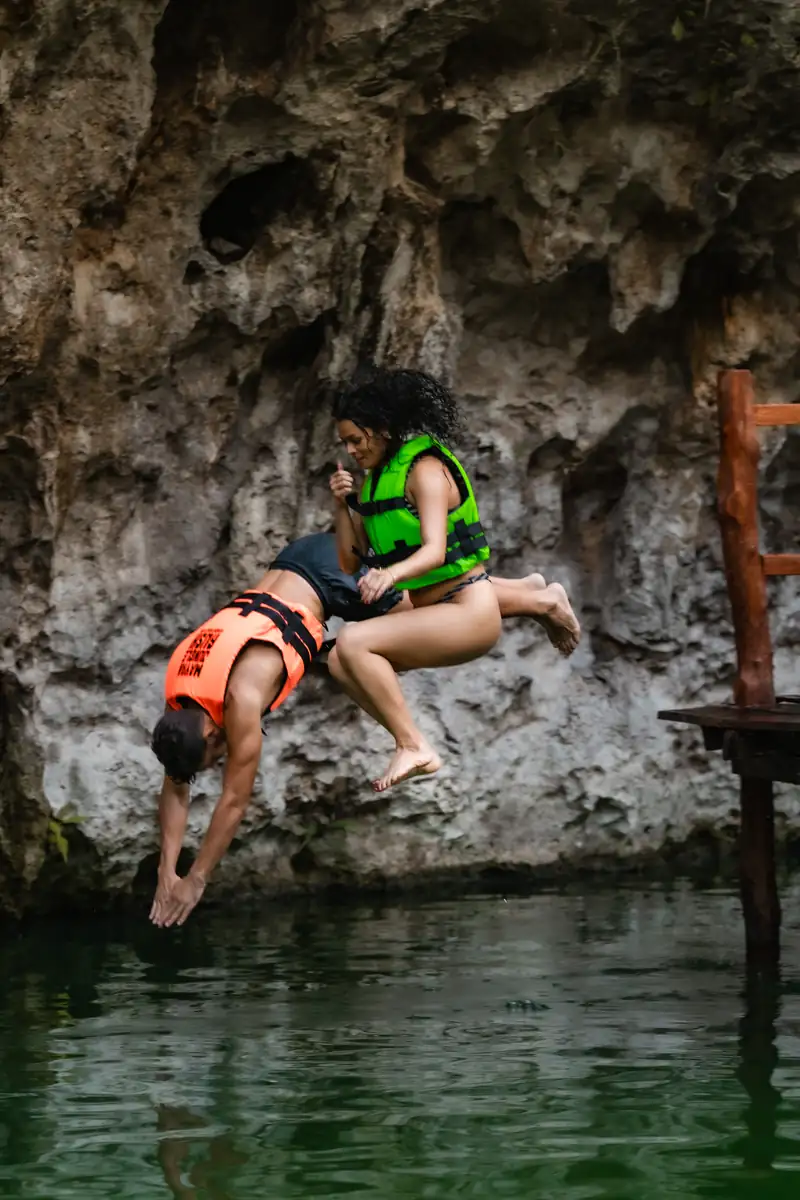 Swimmer jumping into a clear freshwater cenote