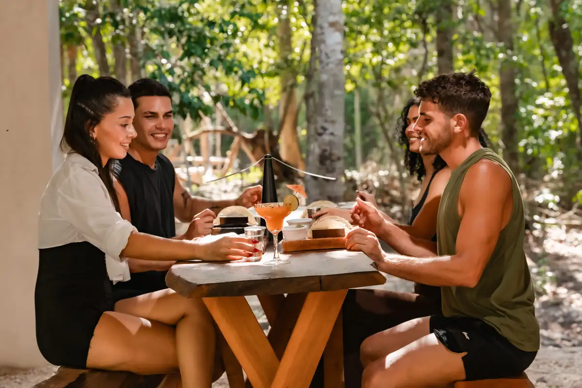 Group of friends toasting at a table in the jungle