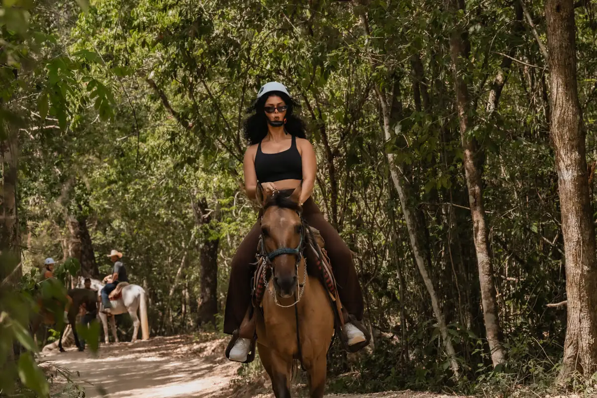 Woman riding a horse on a jungle trail near Cancun