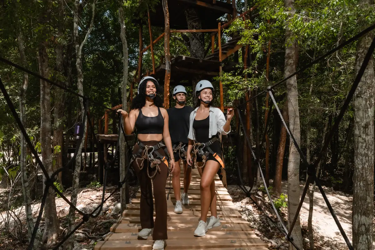 Friends crossing a suspension bridge in the jungle canopy